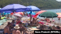 Beachgoers seek the shade in Canj, Bar municipality, Montengro.