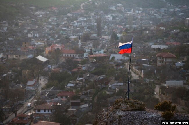 Российский флаг над крымским городом Бахчисарай в аннексированном Крыму, 28 марта 2014 года
