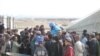 Militarul român Marius Popența în mijlocul unui grup de copii afgani. Poartă echipament de protecție albastru al personalului ONU