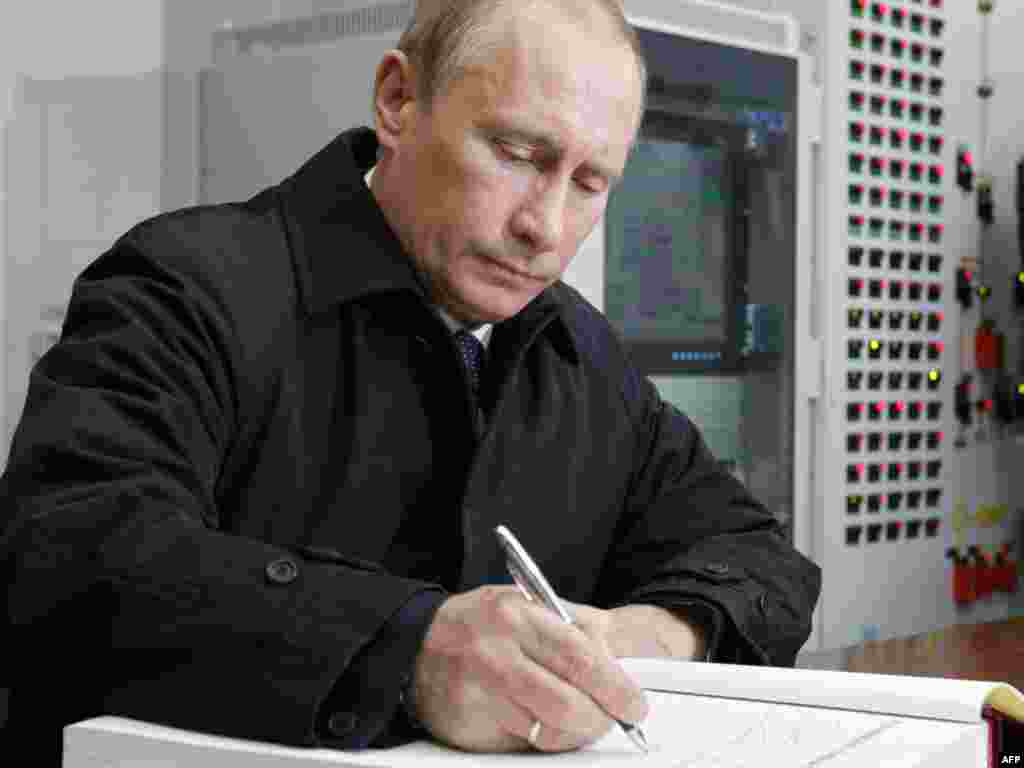 Рускиот премиер Владимир Путин се потпишува во книгата на посетители во нуклеарката во Волгодонск