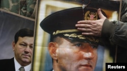 Portraits of Ante Gotovina (foreground) and Mladen Markac are seen as people celebrate the court decision in Zagreb.