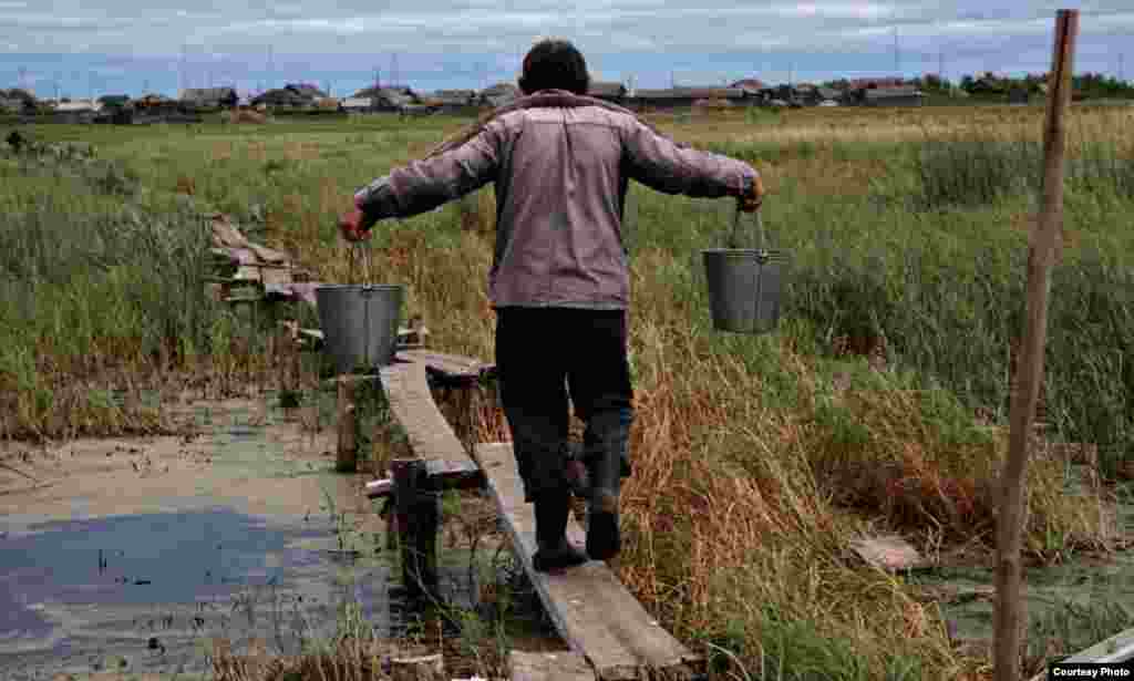 A man carries water from the lake.