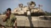 An Israeli soldier prays in front of a tank at a military staging area near the border with the Gaza Strip on July 24. (Reuters/Nir Elias)