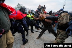 Law enforcement officers scuffle with violent pro-Trump supporters outside the U.S. Capitol in Washington.