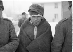 A captured Soviet soldier wears a borrowed hat.