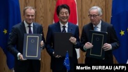 Erkin söwda ylalaşygyna Ýaponiýanyň premýer-ministri Şinzo Abe, Ýewropa Geňeşiniň prezidenti Donald Tusk we Ýewropa Komissiýasynyň prezidenti Jean-Claude Juncker dagy gol goýdy. 17-nji iýul, 2018 ý.