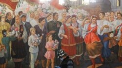 Muškarac s zaštitnom maskom prolazi pored murala u metrou, Moskva, 13. maj