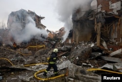 Firefighters work at the site of a residential building damaged during Russian strikes on Kyiv on February 22.
