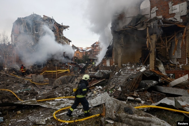 Zjarrfikësit në vendin e një ndërtese banimi të dëmtuar gjatë sulmeve ruse në Kiev më 22 shkurt.