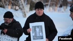 Саратов гIаларчу юкъараллин жигархо Хвостов Антон ву "Свободу Оюбу Титиеву!" (Маьрша ваккха Титиев Оюб) йоза тIехь долу плакат а карахь.