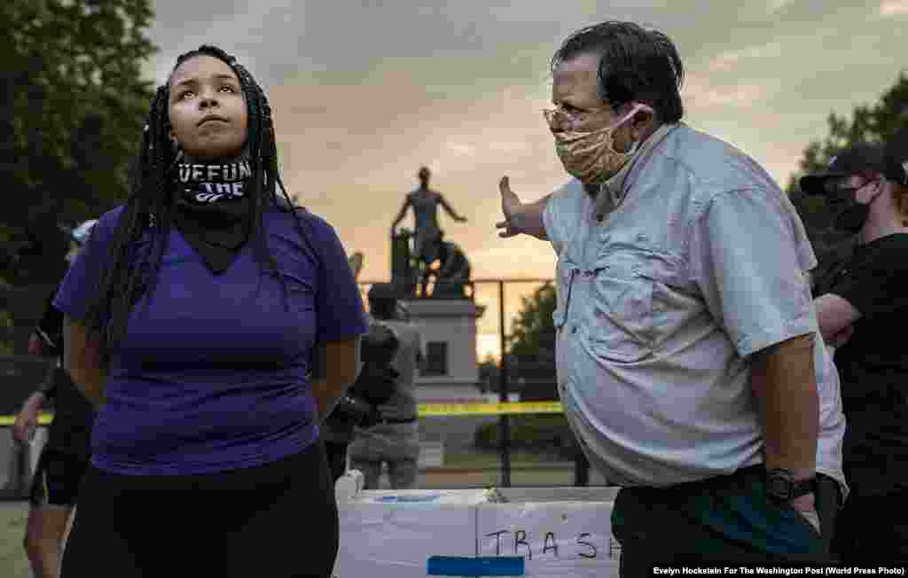 Helyszíni hír kategóriában a Washington Post fotóriportere, Evelyn Hockstein nyert. A képen a washingtoni Lincoln Parkban található Felszabadítási emlékmű eltávolításáért tüntető nőt próbál éppen az ellenkezőjéről meggyőzni egy férfi 2020. június 25-én.&nbsp;