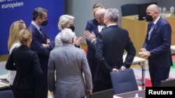 European Commission President Ursula von der Leyen (center) speaks with European Council President Charles Michel (third from right) with other EU leaders during a special meeting of an emergency summit called to discussion Russia's invasion of Ukraine. 