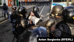 Полицијата приведува демонстрант на протестите во Москва 
