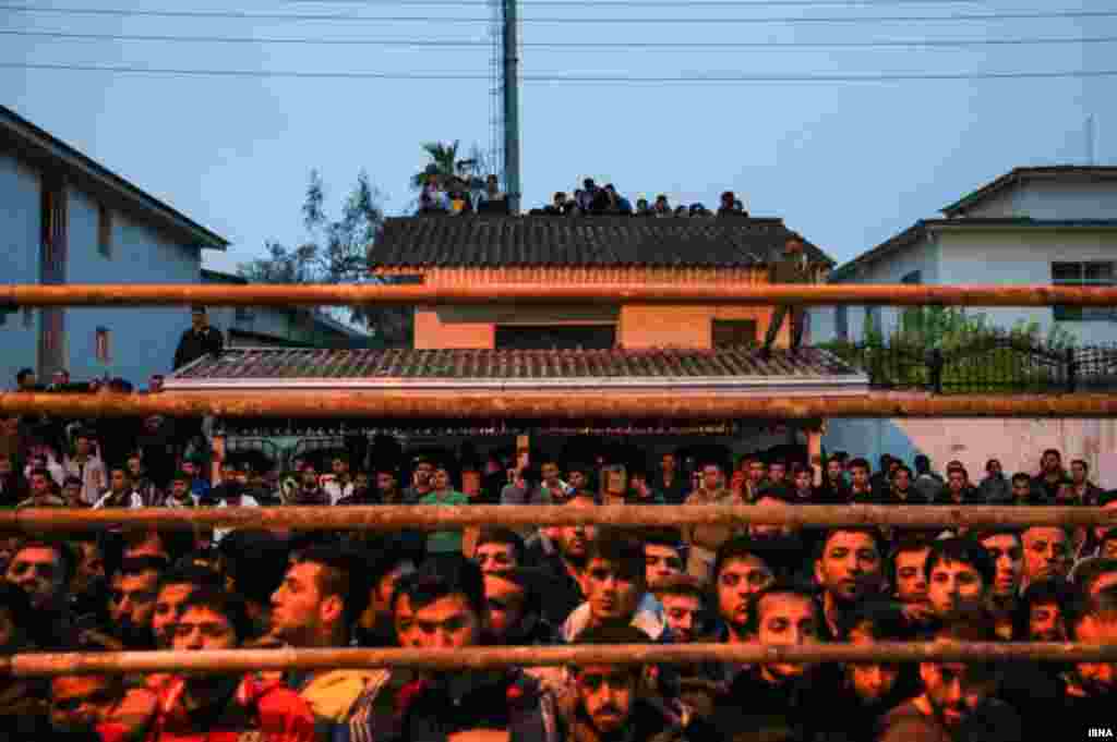 People gather to watch the planned execution in the town of Noor in Mazandaran Province.