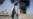 A Taliban fighter walks as smoke rises after Pakistani air strikes hit oil depots for commercial airlines, near the Kandahar airport in March. 
