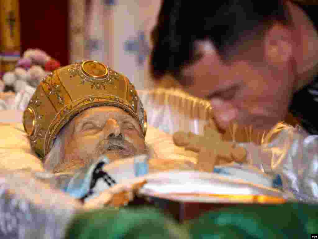 A man kisses the hand of the late Serbian Orthodox Patriarch Pavle during a memorial service in Belgrade on November 15.