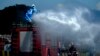 Workers wearing protective gear spray disinfectant on a street at a residential area in Islamabad on March 29.