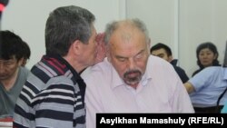 Сотқа тартылып жатқан актер Тұңғышбай Жаманқұлов (оң жақта) адвокаттарының бірімен сөйлесіп отыр. Алматы, 24 мамыр 2017 жыл