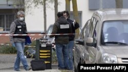 Police officers work near the site where Rahim Namazov and his wife were targeted by gunfire in Colomiers, France.