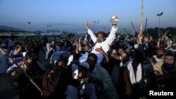 Islamist activists carry one of their party leader on their sholders during a sit in protest against the execution of Mumtaz Qadri outside the Parliament building in Islamabad, Pakistan ob March 30.