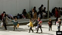 Refugees and migrants arrive at Galatsi Olympic Hall near Athens, Greece, on October 1.