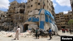 People inspect the damage at the Al-Quds hospital in Aleppo after it was hit by air strikes.