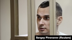 Ukrainian film director Oleh Sentsov looks on from a defendants cage as he attends a court hearing in Rostov-on-Don in August 2015.