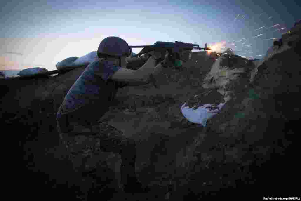 Боєць веде вогонь з автомату Калашникова в напрямку позицій сепаратистів