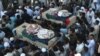 Pakistani mourners carry the coffins of blast victims during their funeral a day after a suicide bomb attack in Lahore last month.