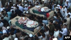 Pakistani mourners carry the coffins of blast victims during their funeral a day after a suicide bomb attack in Lahore last month.
