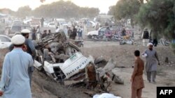 Pakistani residents gather at the site after a bomb blast in Bannu on November 26.
