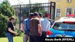 Полиция задерживает прибывших к зданию Жамбылского областного суда на процесс по делу местного активиста Абая Жундибаева. Тараз, 11 мая 2020 года.