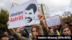 Protesters hold portraits of activist Astrit Dehari in Pristina on November 5.