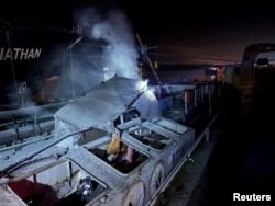 Дим над судном, пошкодженим під час нічних ударів російського безпілотника в порту в Одеській області, Україна, 26 грудня 2025 року