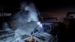 Архивна снимка на последствията от руска атака по пристанището в Одеса на 26 декември. Дим се издига над кораб, който е бил повреден по време на нощни руски удари с дрон.