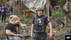 Полицейские осматривают последствия российского ракетного удара по зоне отдыха на окраине Харькова, 19 мая 2024 года