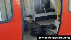 Personal belongings and a bucket with an item on fire inside it are seen on the floor of an underground train carriage at Parsons Green station in London on September 15.