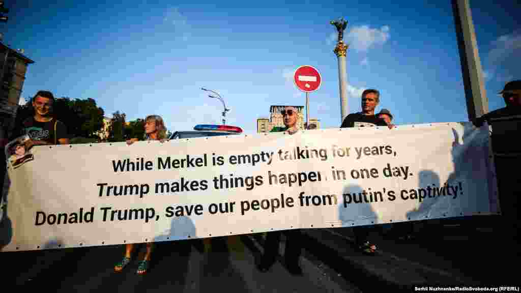 Активисты верят, что президент США Дональд Трамп способен решить судьбу заключенного в России Олега Сенцова за один день, в то время, как канцлер Германии Ангела Меркель занимается &laquo;пустыми разговорами&raquo;. Об этом гласит плакат&nbsp;&nbsp;