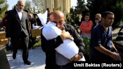 Timur Xaligov carries the body of his 10-month-old daughter Narin, who was killed with five other relatives, including her mother, Sevil, when a rocket hit their home in the city of Ganca, Azerbaijan, on October 17.