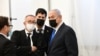 Benjamin Netanjáhú izraeli miniszterelnök a jogi csapatával a politikus korrupciós ügyét vizsgáló egyik bírósági meghallgatás előtt, 2021. február 8-án. 