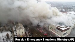 Дым над зданием торгового центра, в котором произошел пожар. Кемерово, 25 марта 2018 года.