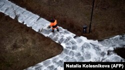 Komunalni radnik dezinficira pješačku stazu, Moskva, 5. april 