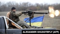 Український боєць веде вогонь в напрямку позицій російських гібридних сил біля села Бугас на Донеччині, 24 жовтня 2014 року