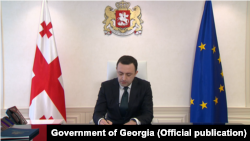 Премьер-министр Грузии Ираклий Гарибашвили подписывает заявление на вступление в ЕС