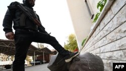 Антивладин борец гази врз главата на статуата на починатиот сириски претседател Хафез ал-Асад, која беше соборена пред седиштето на Министерството за одбрана во областа Кафр Соуса во Дамаск на 9 декември 2024 година.