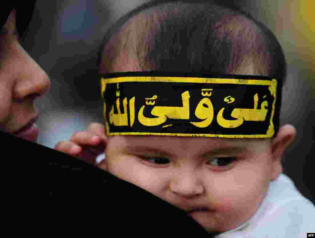 A Pakistani Shi'ite Muslim woman holds her baby as she takes part in a rally against Israel and the United States to mark Al-Quds (Jerusalem) Day on the last Friday in the holy month of Ramadan in Karachi. (AFP/Rizwan Tabassum)