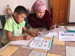 Гульжан Кульбаева делает уроки с сыном.