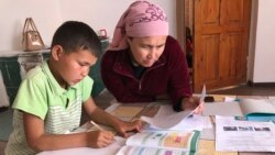 Жительница Туркестанской области учит уроки с сыном. Иллюстративное фото.