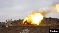 Free Syrian Army reacts as they launch a shell towards forces loyal to Syrian President located in Deraa, January 11, 2016