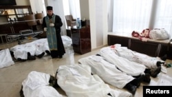 Sveštenik stoji u holu Hotela Ukrajina, okružen telima učesnika protesta Evromajdan, koji su ubijeni tokom sukoba sa policijskim jedinicama za razbijanje demonstracija u Kijevu, 20. februar 2014.